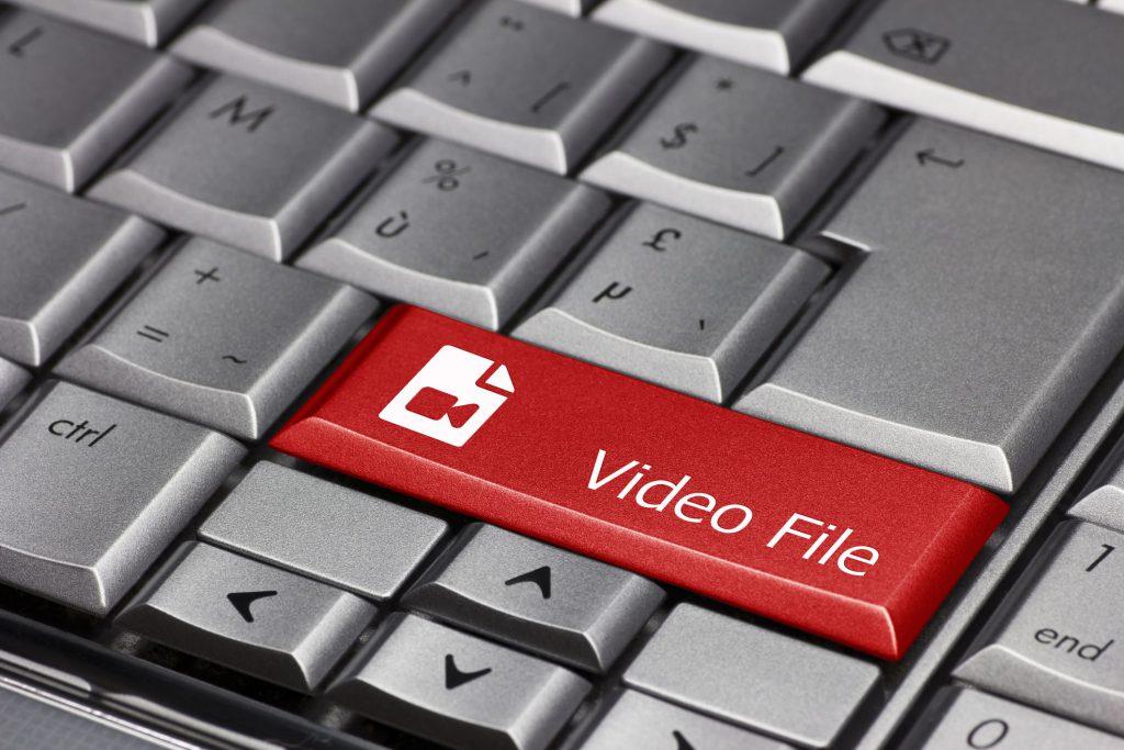 A large red video file button on a gray keyboard.